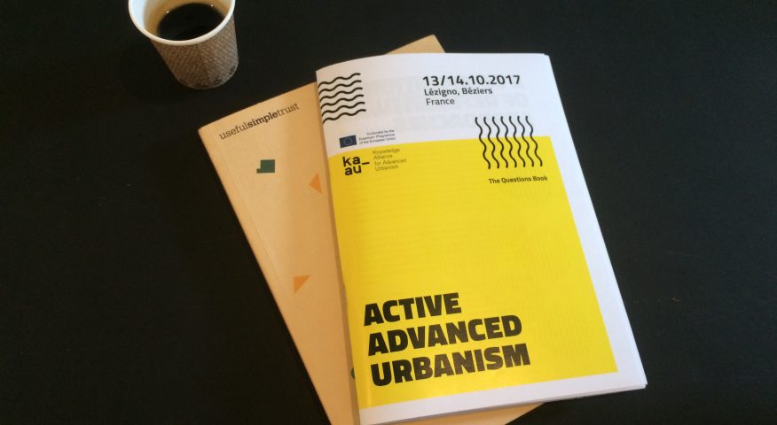 Image shows front cover of the Active Advanced Urbansim booklet and a cup of coffee
